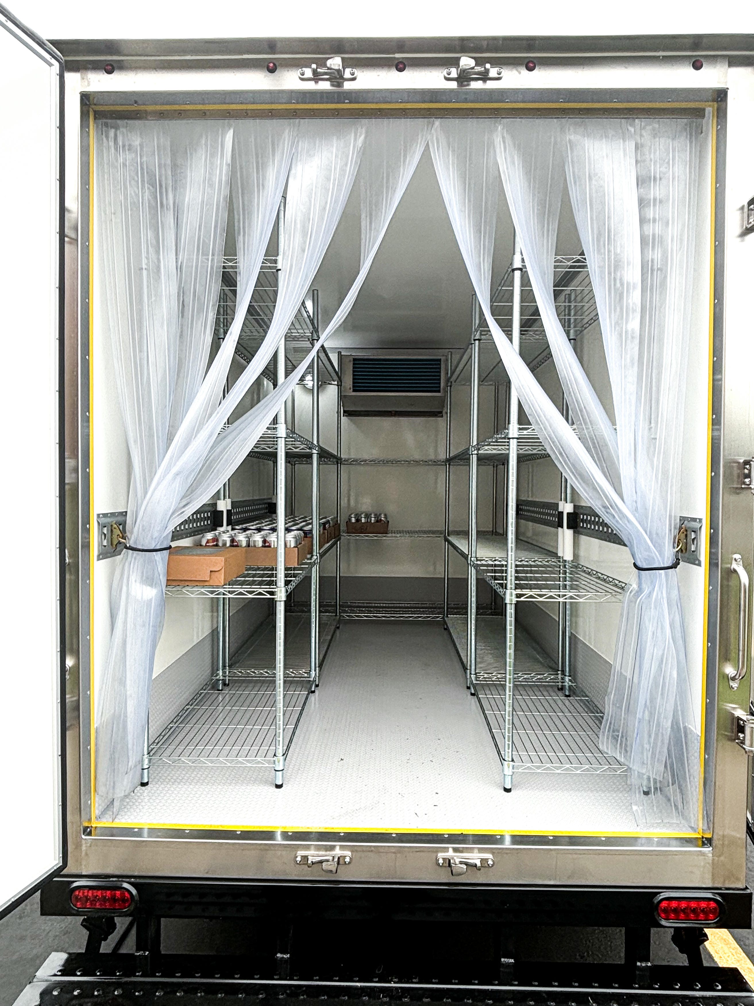 Mobile refrigerated trailer with beverage and box storage on wire shelves for event rental