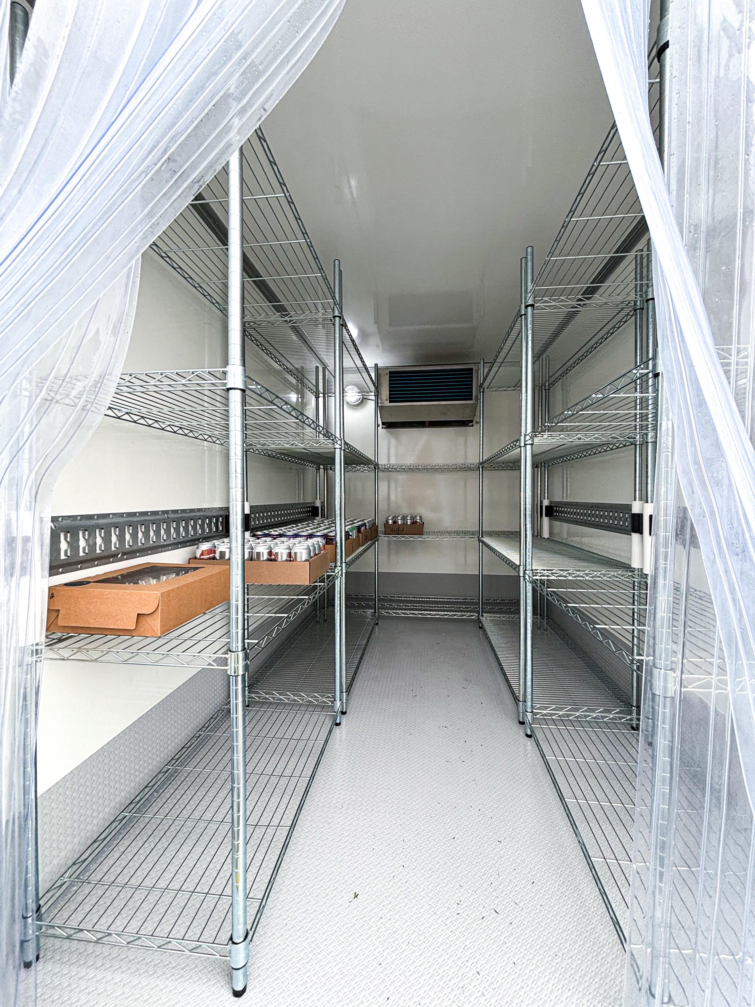 Refrigerated trailer interior aisle with wire shelving for event and catering cold storage rental